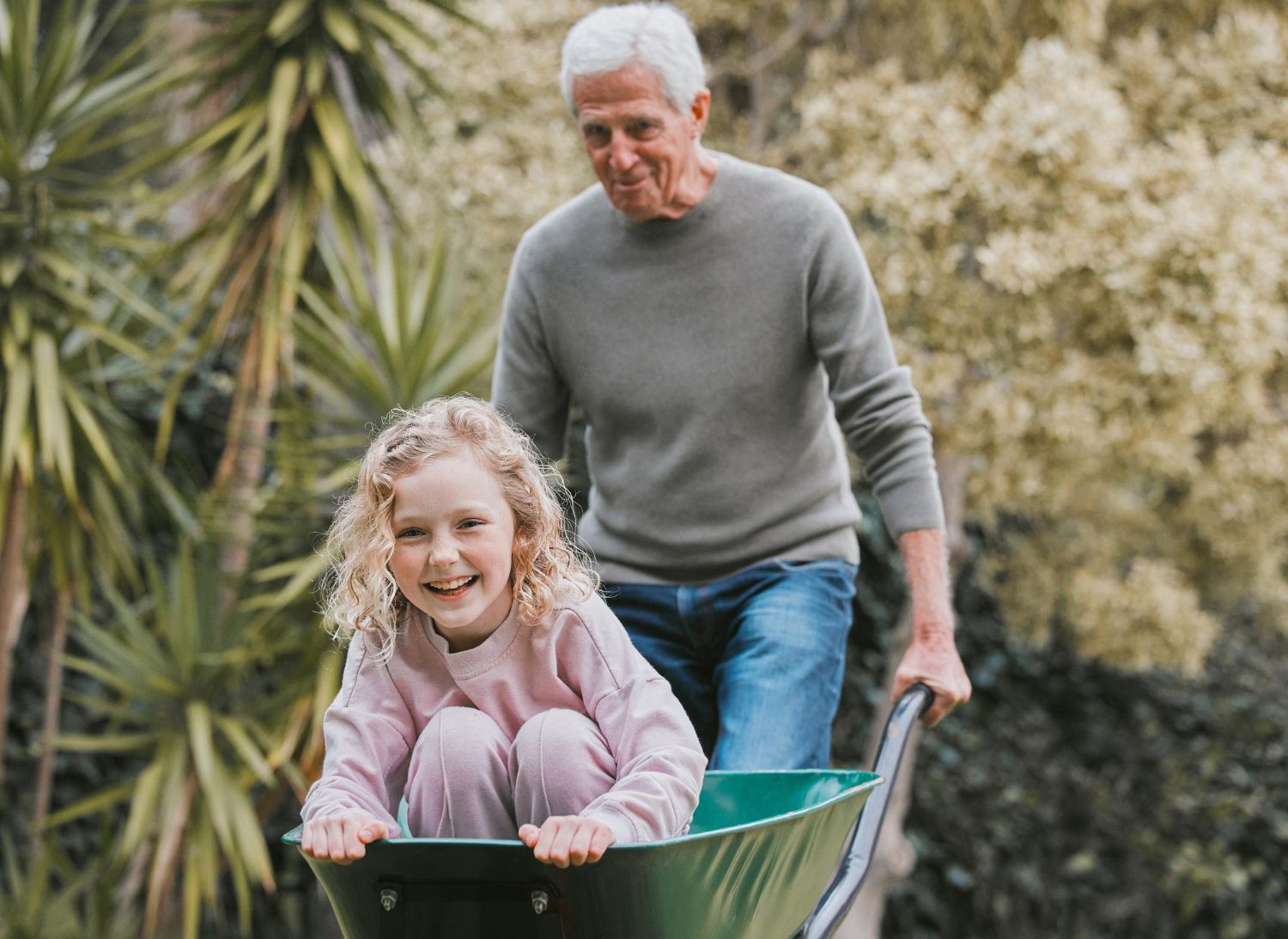 Grandfather plays with grandchild in garden