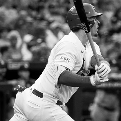 Black and white image of St. Louis Cardinals baseball player looking out to the field after swinging his bat