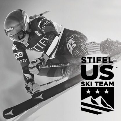 Black and white image of United States skier going down hill with black U.S. ski team logo on the bottom right