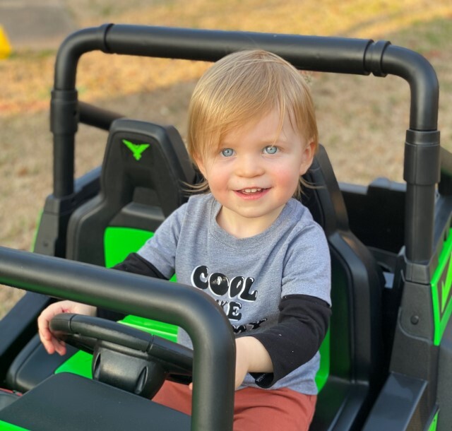 Grandson riding toy Jeep age 3