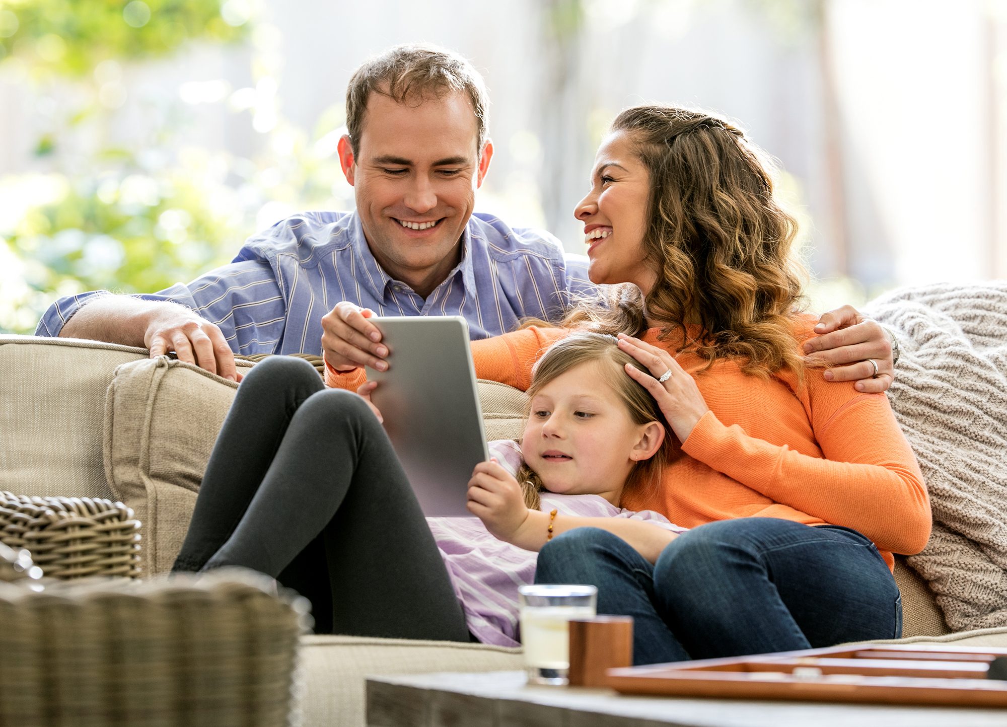 family on couch with tablet
